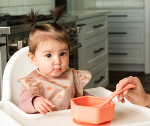 baby girl using the Tiny Twinkle's Easy Bib with Ruffles in Boho Rainbow