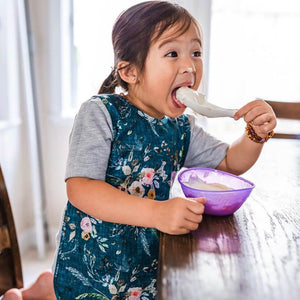 Toddler using BapronBaby Bohemian Floral Bapron Bib-Apron
