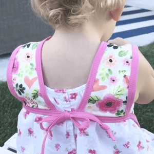 Toddler using BapronBaby Bubblegum Floral Bapron Bib-Apron